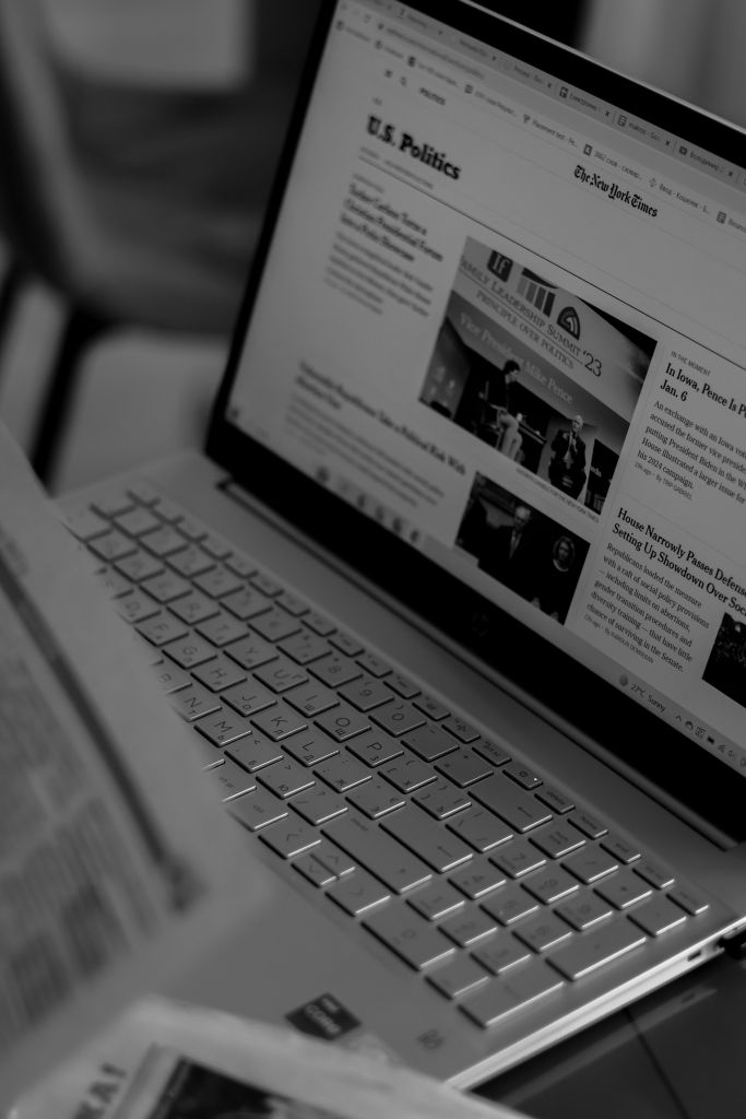 Black and white photo of a laptop showing a news website.